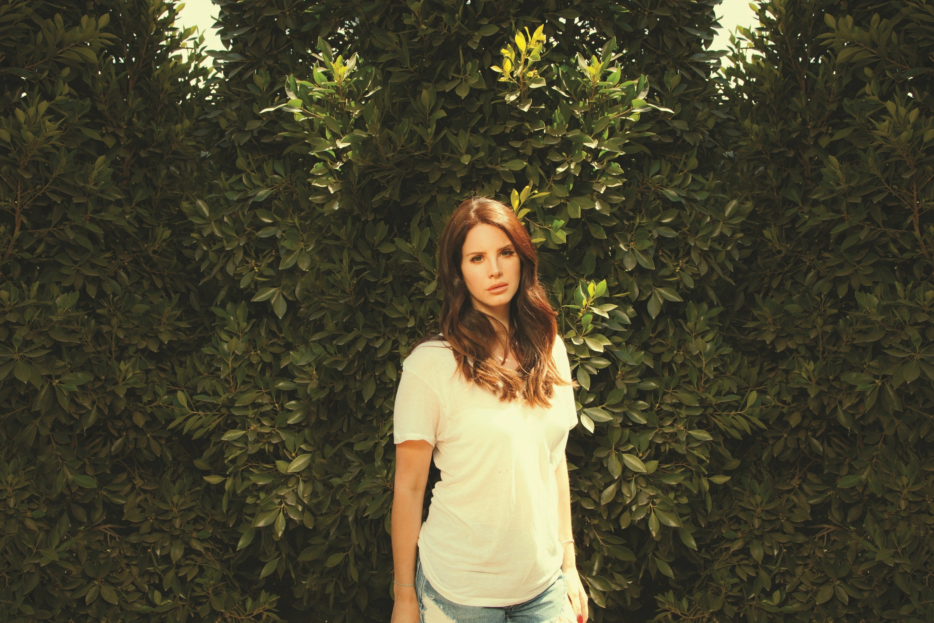 Портрет Lana Del Rey на фоне зелёной листвы - 1